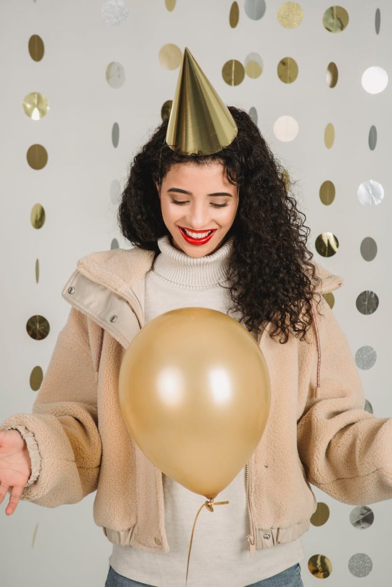 smiling woman with balloon in decorated room